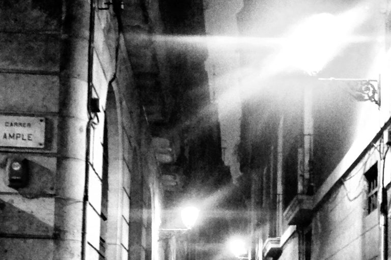 Dunkle, enge Gasse mit schwachem Licht, Verbinden im Lichtkegel und verschwommenen Schatten.